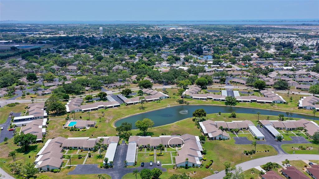An aerial view shows a residential complex with a pond and a circled unit — 6129 HERITAGE LANE W UNIT 6129, BRADENTON, FL