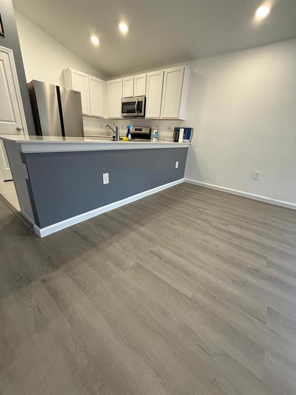 A kitchen with white cabinets, stainless steel appliances, and a gray island with a countertop — 1970 SARAH STREET, WINTER HAVEN, FL