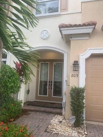The exterior of a house features a double front door, a brick walkway, and landscaping — 1000 Us-1 # 805, Jupiter FL 33477, JUPITER, FL