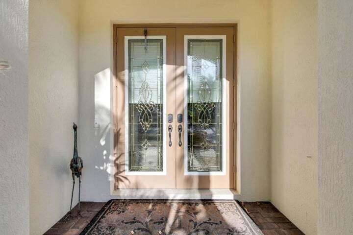 A front entryway features double doors with decorative glass panels and a metal crane statue — 1000 Us-1 # 805, Jupiter FL 33477, JUPITER, FL