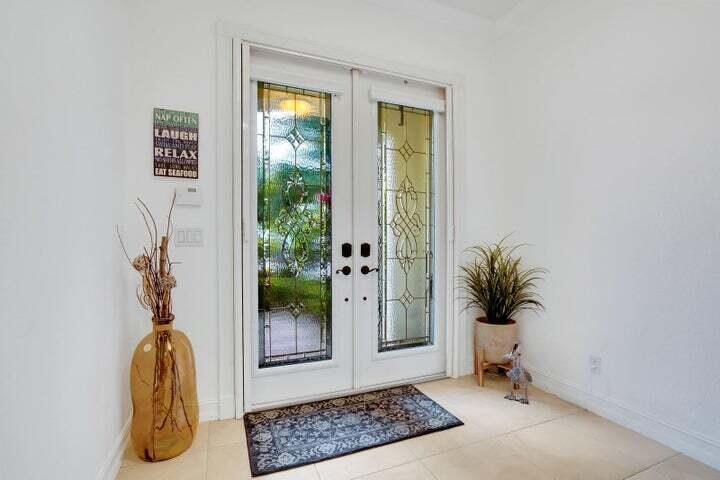 An entryway features double glass-paneled doors, a decorative floor mat, and a large glass vase — 1000 Us-1 # 805, Jupiter FL 33477, JUPITER, FL