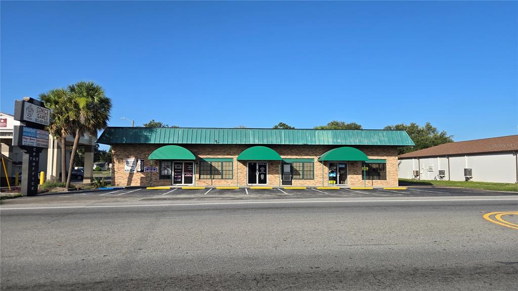 A single-story brick commercial building with three green awnings and a metal roof — 5720 GALL BOULEVARD UNIT 2, ZEPHYRHILLS, FL