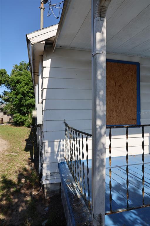 A side view of a house exterior featuring a porch with a blue floor and railing — 232 C STREET, LAKE WALES, FL