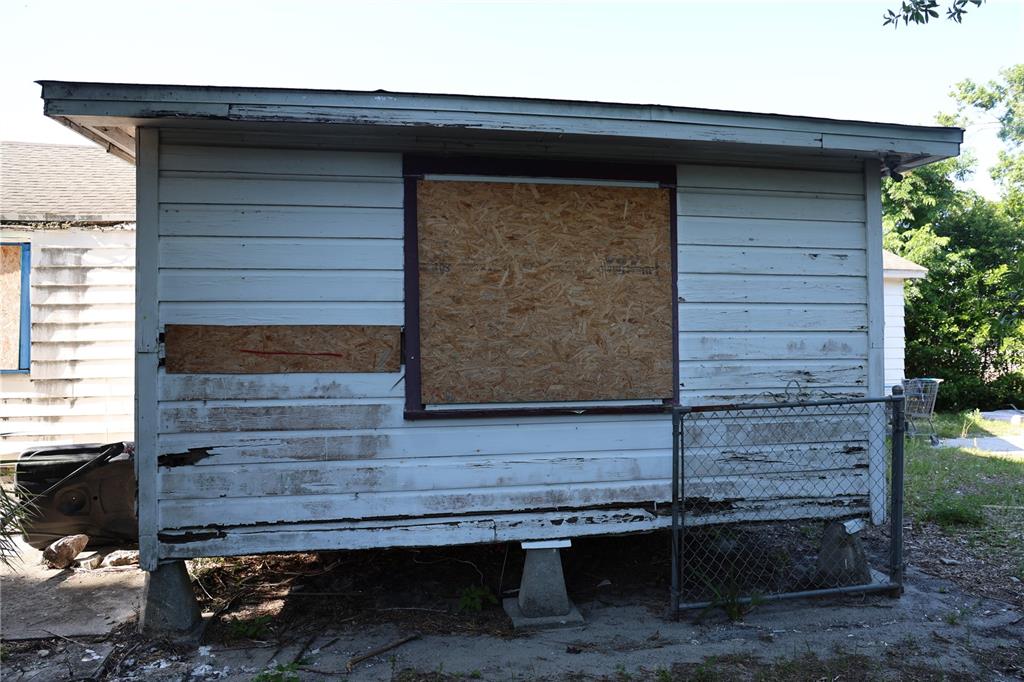 The exterior of a small, weathered shed with light blue siding and a boarded-up window — 232 C STREET, LAKE WALES, FL
