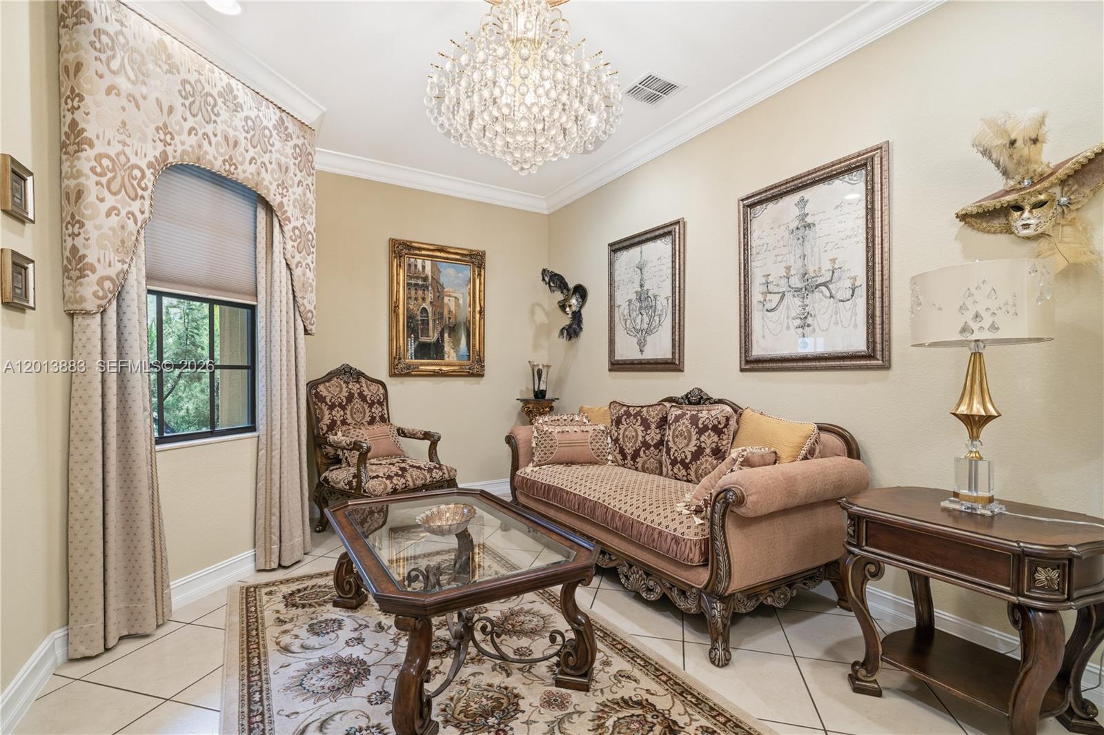 A formal living room features ornate traditional furniture, a crystal chandelier, and decorative wall masks — 5574 49th Ave, Vero Beach FL 32967, VERO BEACH, FL