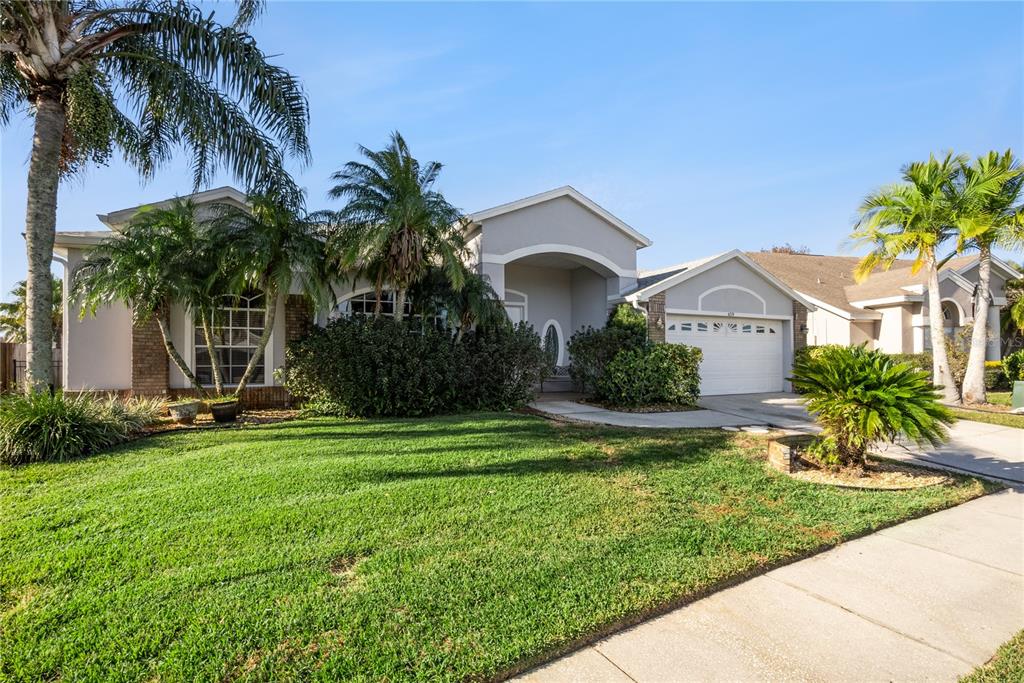 A single-story suburban house with a light gray exterior, a two-car garage, and palm trees — 639 LAKEHAVEN CIRCLE, ORLANDO, FL