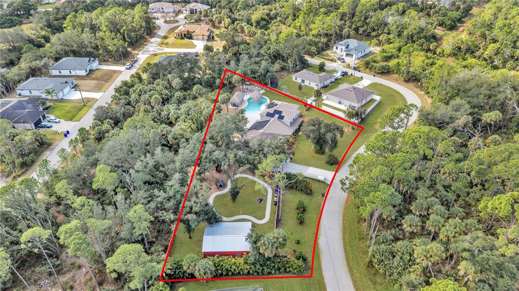 An aerial view shows a house with a pool and a detached garage on a lot — 3694 CRANDON ROAD, NORTH PORT, FL