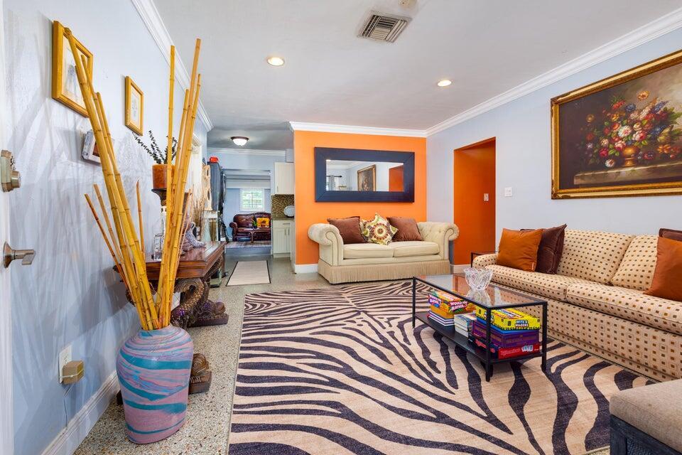 A living room features a zebra-print rug, an orange accent wall, and a beige sofa — 145 SE 3rd Avenue, Boynton Beach FL 33435, BOYNTON BEACH, FL
