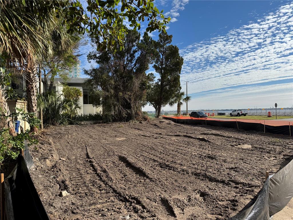 A cleared, dirt-covered vacant lot sits adjacent to trees and a waterfront road — 2715 BAYSHORE BOULEVARD, TAMPA, FL