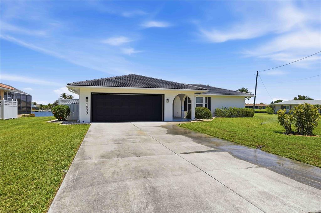 A single-story house with a dark roof, white exterior, and a two-car garage — 1933 FAIRVIEW DRIVE, ENGLEWOOD, FL