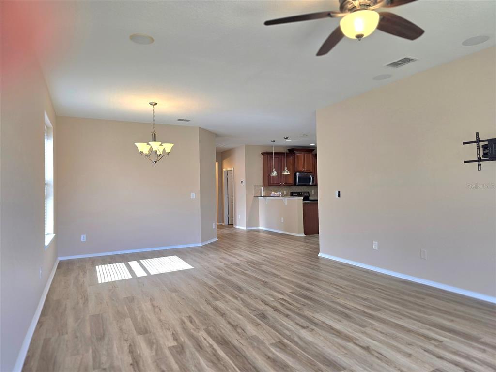 A kitchen features dark wood cabinets, granite countertops, stainless steel appliances, and light-colored flooring — 5646 SUNSET FALLS DRIVE, APOLLO BEACH, FL