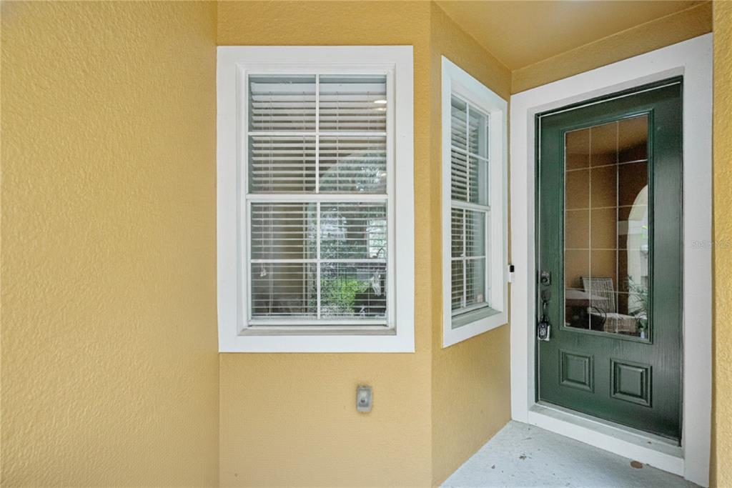 A front entryway features a dark green door with a glass insert and a window — 5080 CYPRESS BRANCH POINT, OVIEDO, FL