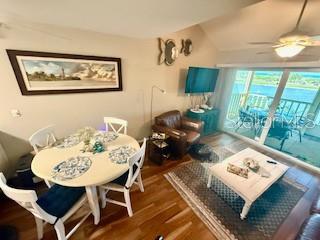 A living and dining area features a round table, leather armchair, and sliding glass doors — 9400 LITTLE GASPARILLA ISLAND UNIT I-9, PLACIDA, FL