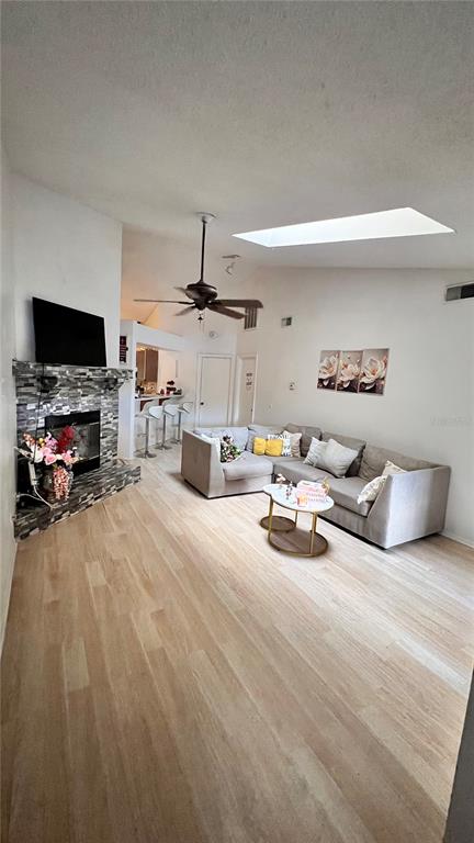 A living room features light wood flooring, a stone fireplace, and a sectional sofa — 5824 RED CEDAR LANE, TAMPA, FL