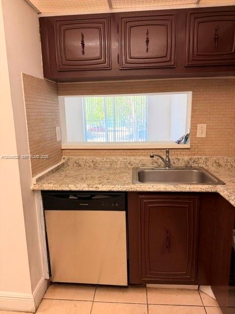 A kitchen features dark wood cabinets, a stainless steel dishwasher, and a window above the sink — 498 NW 165th St Rd # 204, Miami FL 33169, MIAMI, FL