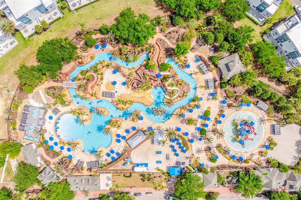 An aerial view of a resort swimming pool complex with a lazy river and slides — 7612 CABANA COURT UNIT 201, REUNION, FL