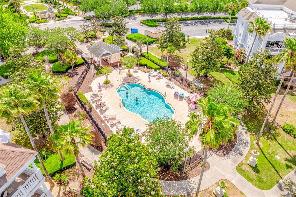 An aerial view of a community swimming pool surrounded by palm trees and lounge chairs — 7612 CABANA COURT UNIT 201, REUNION, FL
