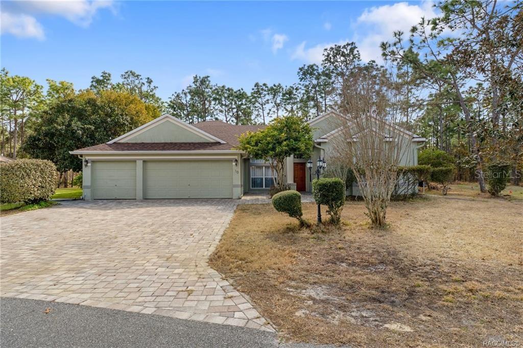 A single-story house with a three-car garage and a paved driveway sits on a lot — 10 BOXLEAF COURT S, HOMOSASSA, FL