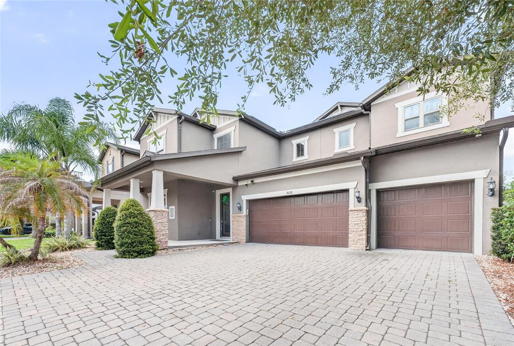 A two-story house with a paved driveway, two garage doors, and a covered front entrance — 9210 ROYAL ESTATES BOULEVARD, ORLANDO, FL
