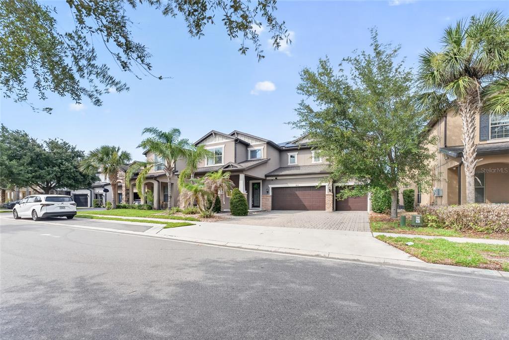 A two-story suburban house with a three-car garage and palm trees in the front yard — 9210 ROYAL ESTATES BOULEVARD, ORLANDO, FL