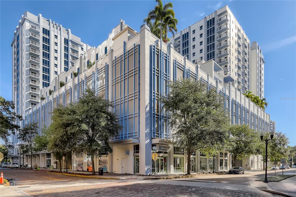 A multi-story building featuring a parking garage base with retail space and high-rise residential towers — 415-2 E PINE STREET, ORLANDO, FL