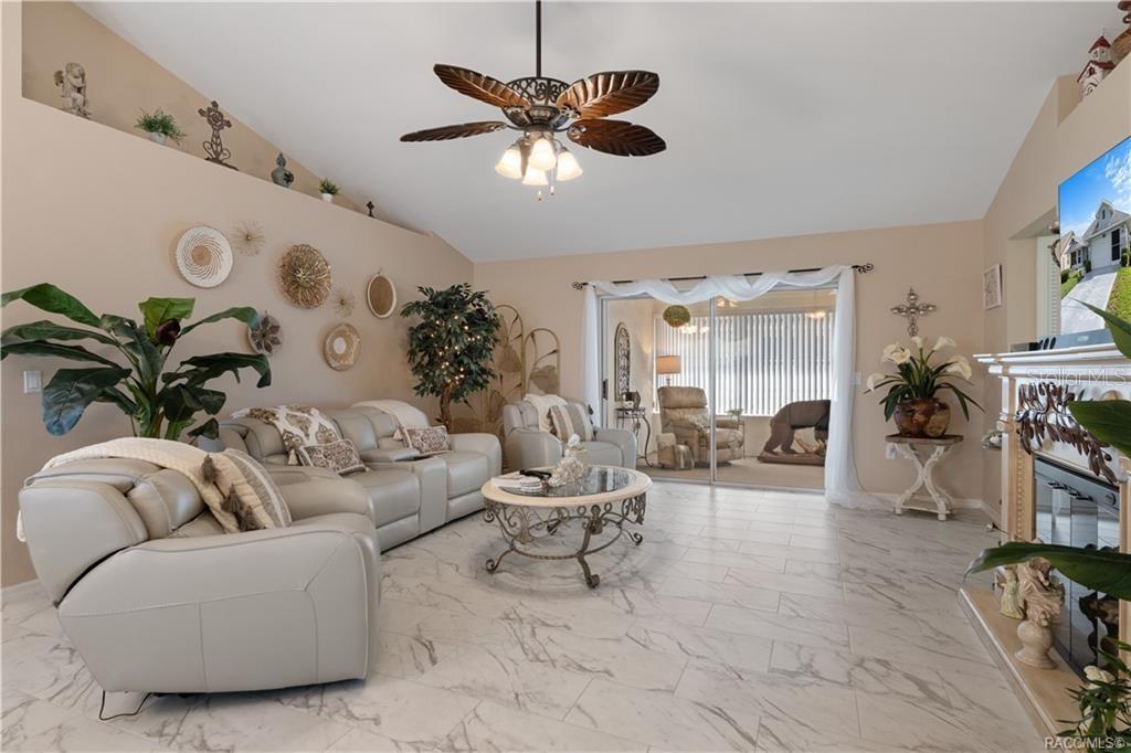 A living room features light-colored leather furniture, a ceiling fan, and marble-look tile flooring — 4271 N STEWART WAY, BEVERLY HILLS, FL