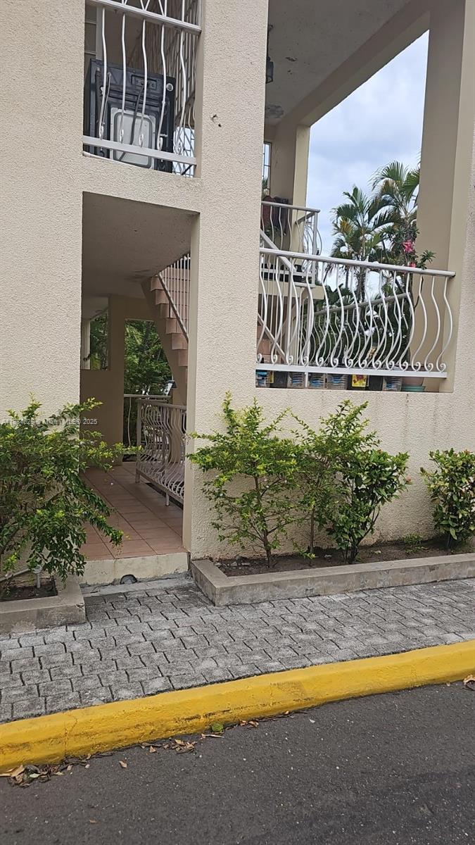 A view of a building exterior featuring a staircase, white railings, and small green shrubs — 00 Waterloo Rd, Kingston Jamaica # 01, NA, NA