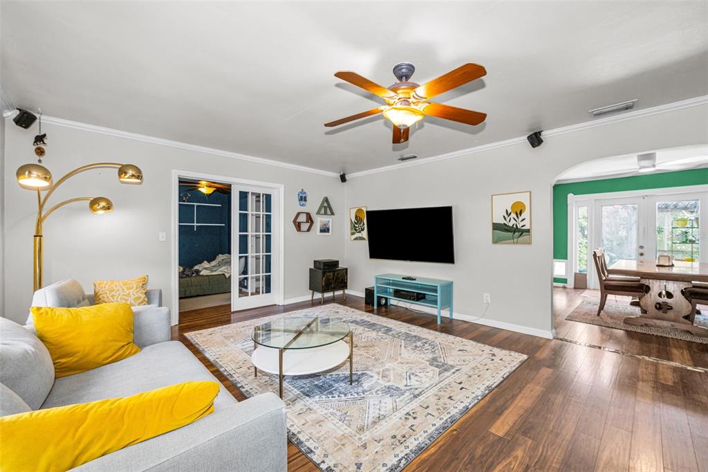 A living room with a grey sofa, a patterned rug, and a television on the wall — 4994 17TH AVENUE N, ST PETERSBURG, FL