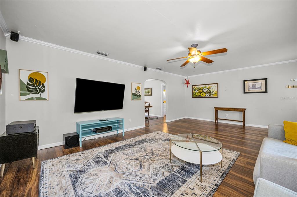 A living room features light gray walls, dark wood floors, a large area rug, and television — 4994 17TH AVENUE N, ST PETERSBURG, FL