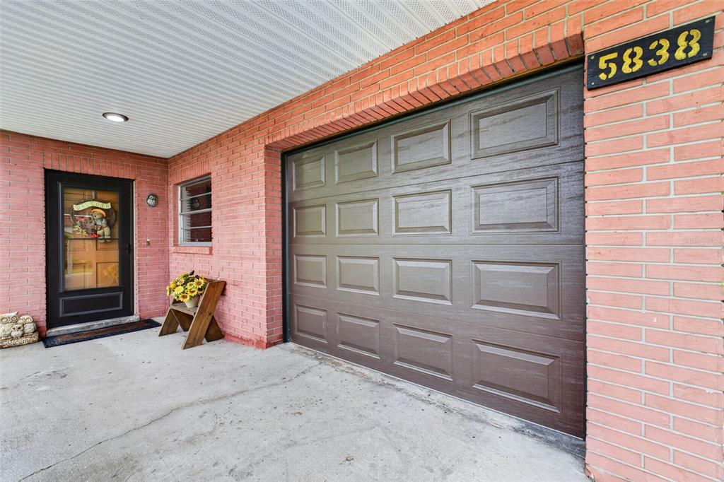 A brick exterior features a dark brown garage door, a front door, and a house number — 5838 OLD BARTOW EAGLE LAKE ROAD, WINTER HAVEN, FL
