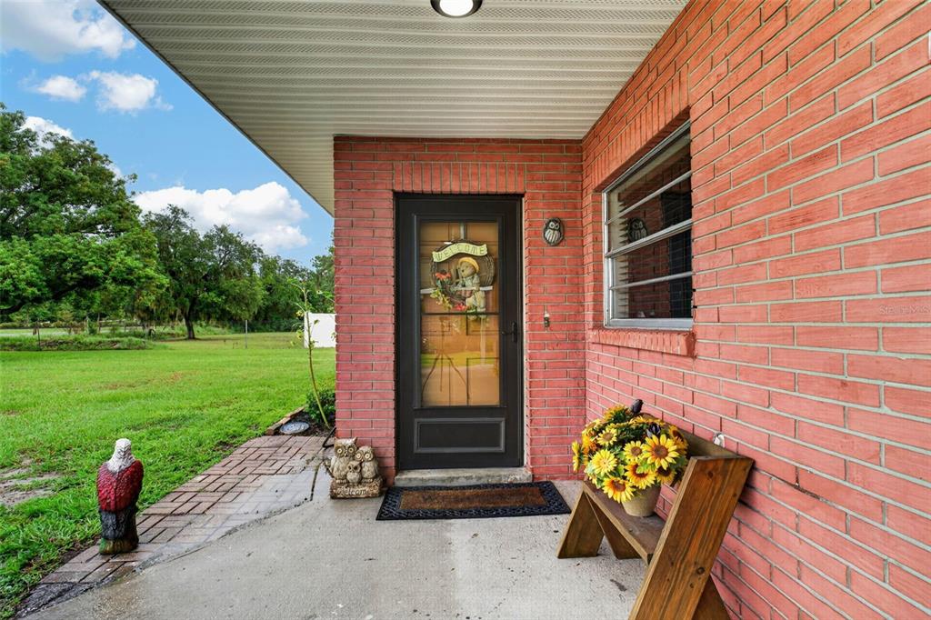 A brick house exterior features a front door with a decorative wreath and a porch — 5838 OLD BARTOW EAGLE LAKE ROAD, WINTER HAVEN, FL