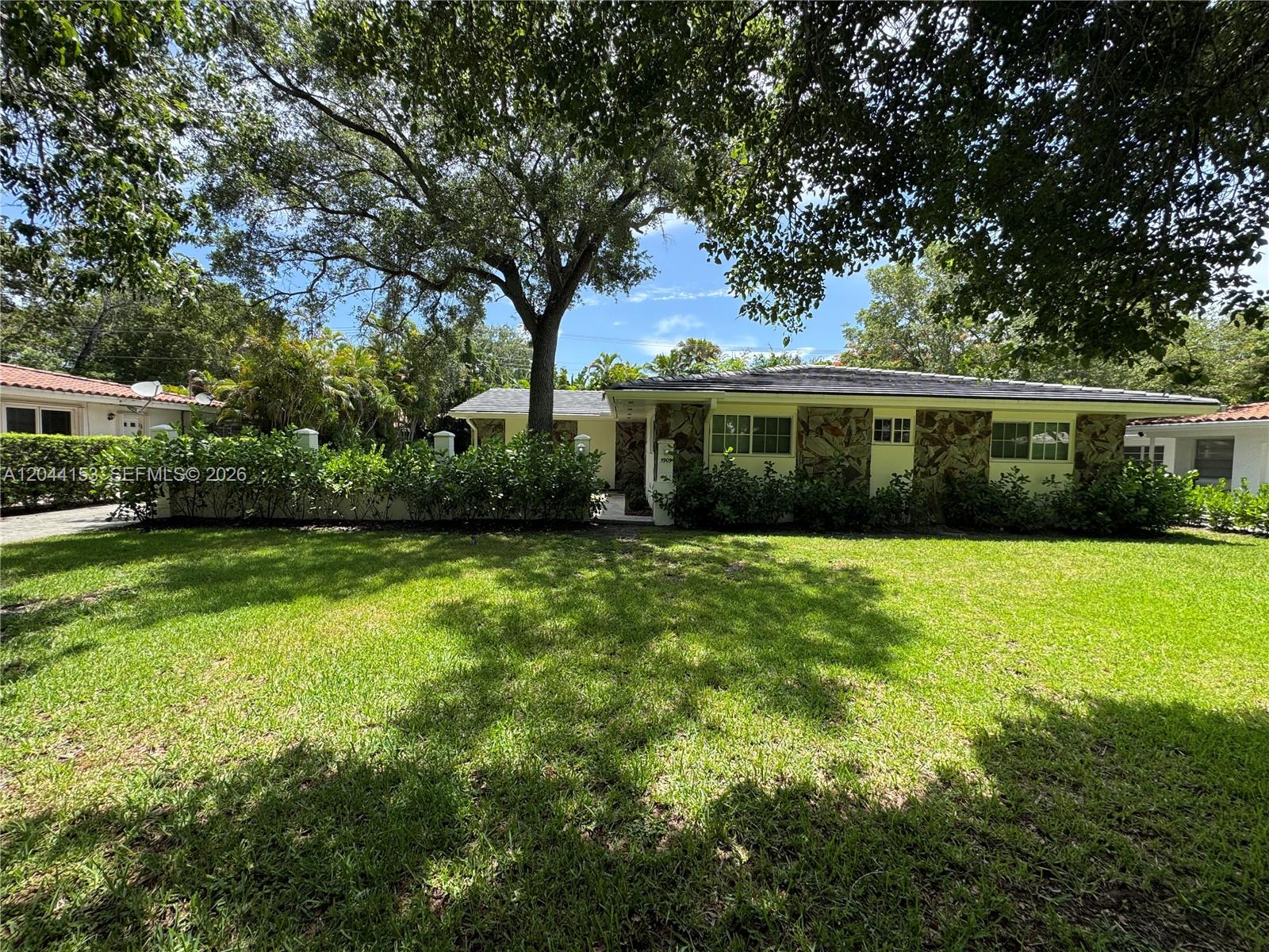 A single-story house with stone accents and a large tree in the front yard — 5907 Turin St # 5909, Coral Gables FL 33146, CORAL GABLES, FL