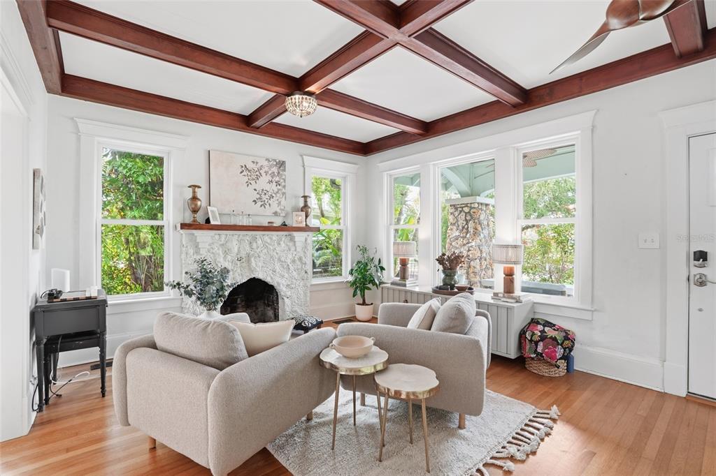 A living room features a white stone fireplace, coffered wood ceiling, and two beige armchairs — 1473 BARCELONA AVENUE, FORT MYERS, FL