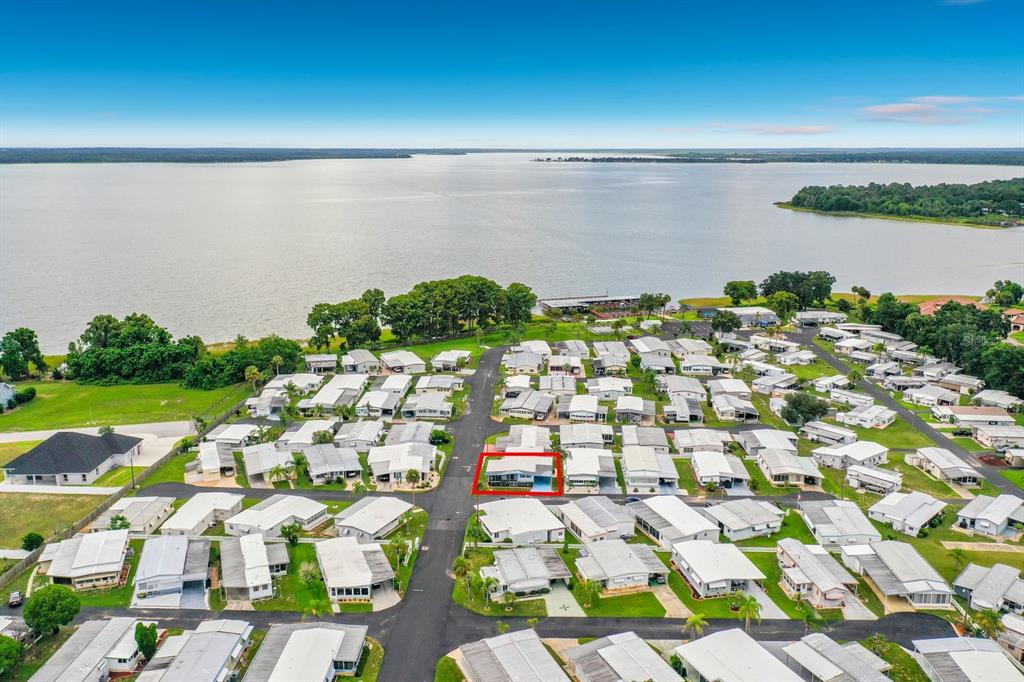 An aerial view shows a mobile home community located near a large lake — 176 SUNSET DRIVE, LEESBURG, FL