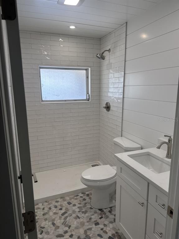 A small bathroom features a walk-in shower, a toilet, and a white vanity with sink — 3755 S SCHOOL AVENUE UNIT 54, SARASOTA, FL