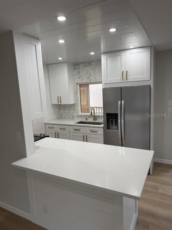 A kitchen with white cabinets, quartz countertops, a shiplap ceiling, and stainless steel appliances — 3755 S SCHOOL AVENUE UNIT 54, SARASOTA, FL