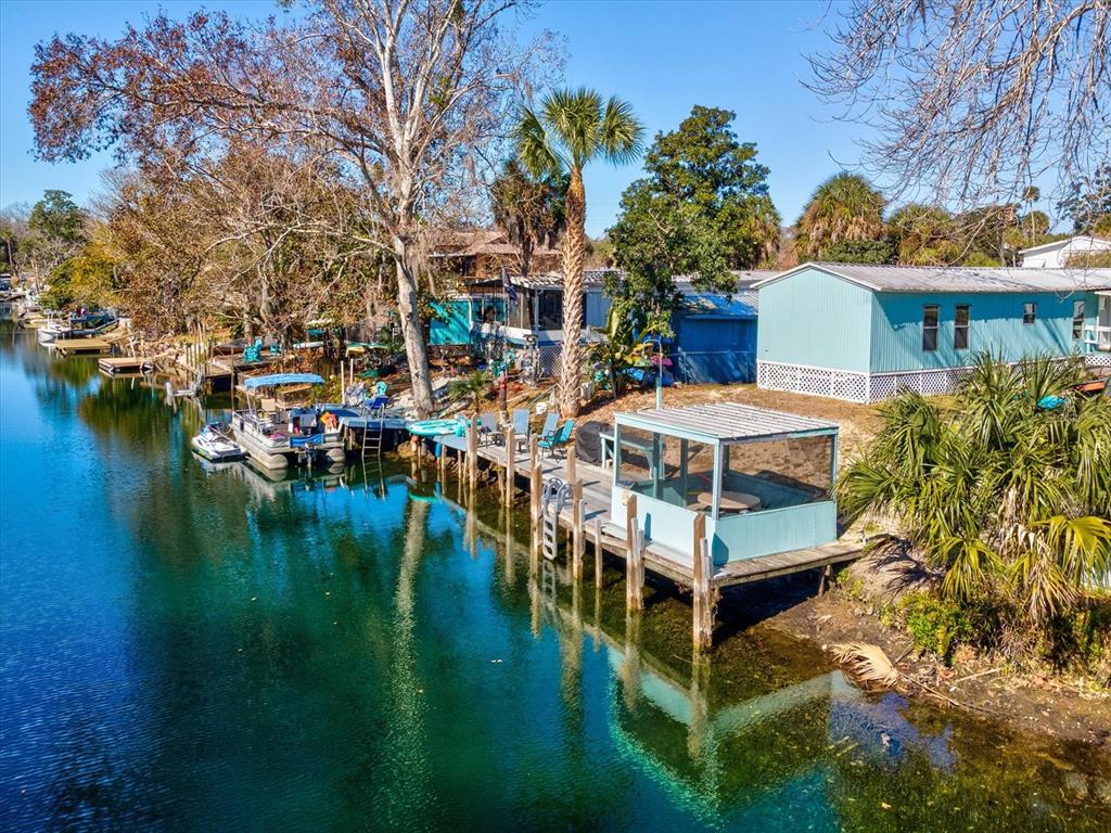 A light blue mobile home sits along a canal with a private dock and gazebo — 6419 W RICHARD DRIVE, WEEKI WACHEE, FL