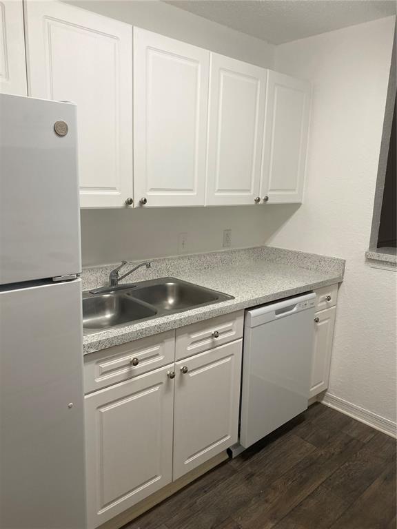 A kitchen with white cabinets, a stainless steel sink, a dishwasher, and speckled countertops — 18001 RICHMOND PLACE DRIVE UNIT 830, TAMPA, FL