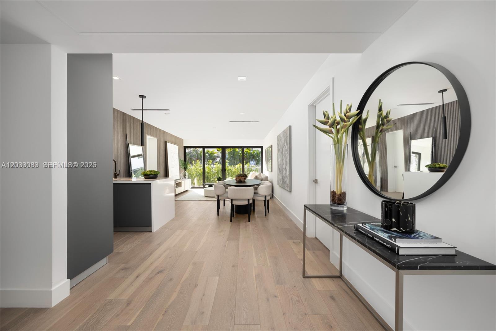 A modern, open-concept living and dining area features light wood floors and a marble console — 202 Sunrise Dr # 202B, Key Biscayne FL 33149, KEY BISCAYNE, FL