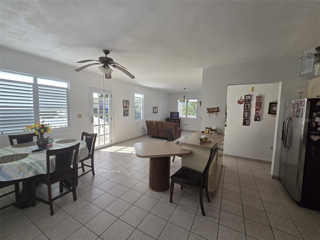 An open-concept kitchen and dining area features tile flooring, a ceiling fan, and white walls — PR 3 BARRIO JUAN MARTIN, YABUCOA, PR