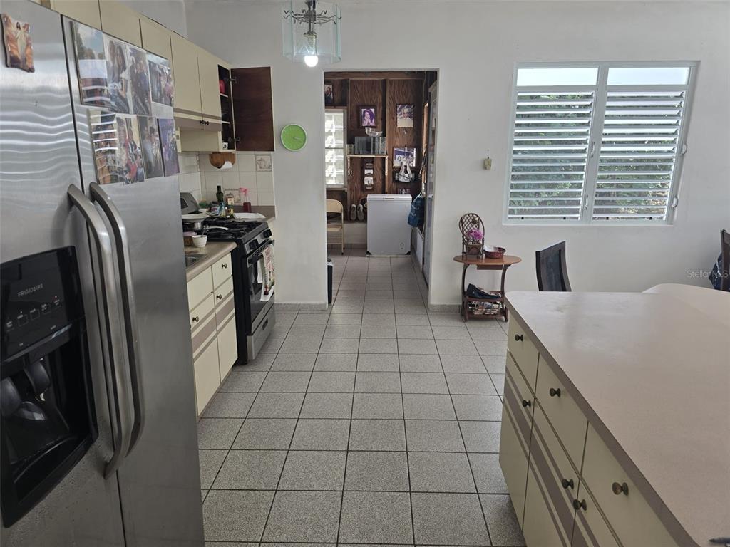 A kitchen with tiled floors, light-colored cabinets, a stainless steel refrigerator, and a center island — PR 3 BARRIO JUAN MARTIN, YABUCOA, PR
