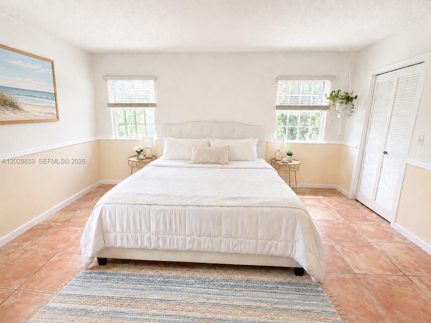 A bedroom features a white bed, two windows, a hanging plant, and terracotta tile flooring — 11921 SW 117th Ct, Miami FL 33186, MIAMI, FL