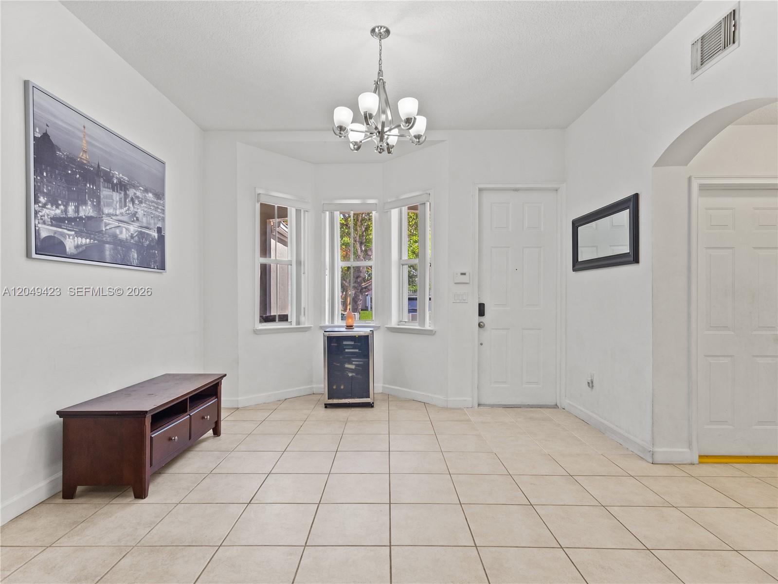 A bright dining area features tile flooring, a bay window, and a modern chandelier — 10183 NW 43rd Ter, Doral FL 33178, DORAL, FL