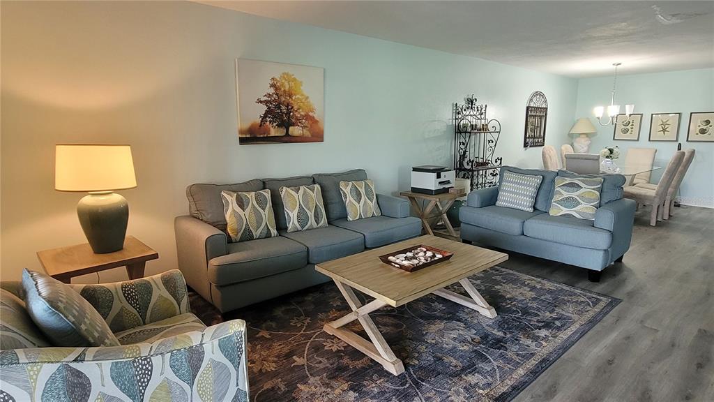 A living room features gray flooring, a sofa, a loveseat, and a sliding glass door — 320 BARCELONA DRIVE UNIT 320, BRADENTON, FL