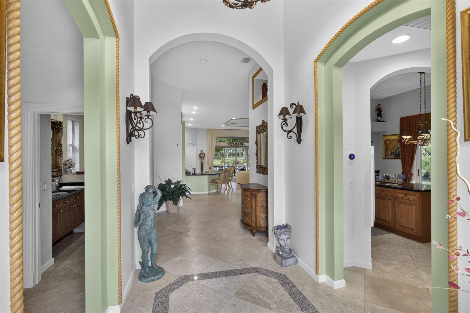 A tiled foyer features arched doorways with green trim and decorative rope molding — 10880 Northgreen Drive, Lake Worth FL 33449, LAKE WORTH, FL