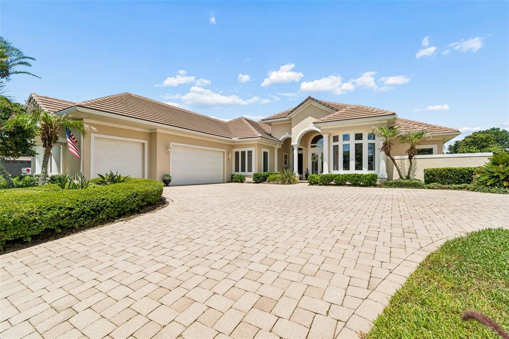 A beige single-story house with a tiled roof and a paved driveway — 12749 GRAND TRAVERSE DRIVE, DADE CITY, FL
