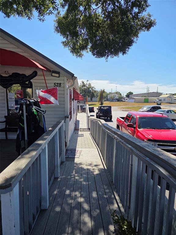 A wooden ramp leads along the side of a building toward a parking lot — 528 E TARPON AVENUE, TARPON SPRINGS, FL