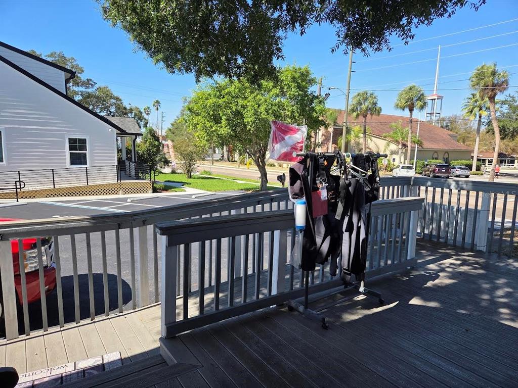 A wooden deck features a clothing rack with wetsuits and a diver down flag — 528 E TARPON AVENUE, TARPON SPRINGS, FL