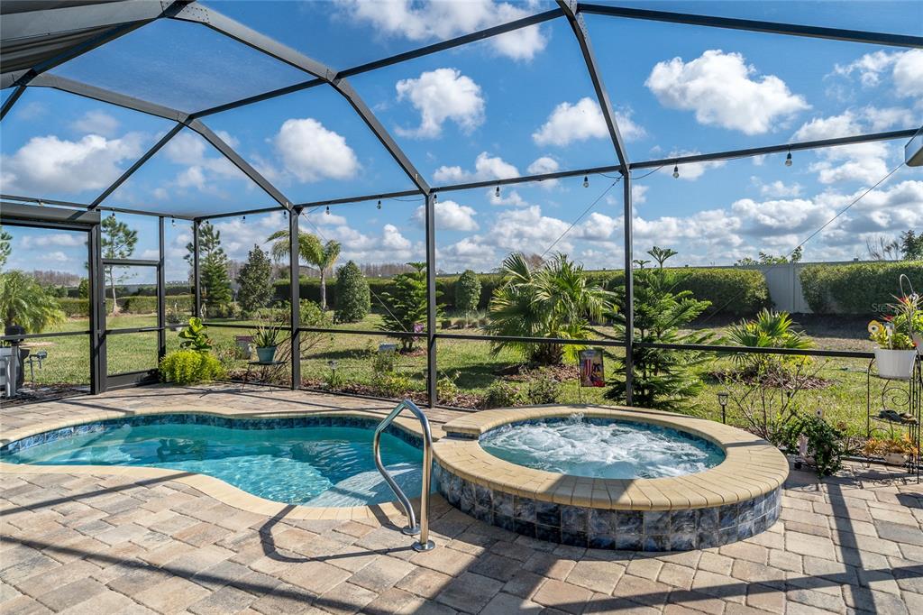 A screened-in patio features a small swimming pool and a raised circular hot tub — 4748 BALLAST CREST COVE, LAND O LAKES, FL