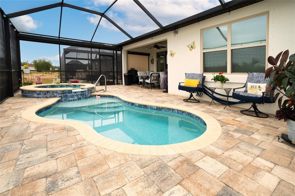A screened-in patio features a small swimming pool, a hot tub, and outdoor seating — 4748 BALLAST CREST COVE, LAND O LAKES, FL